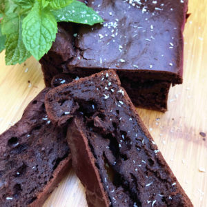 suikervrije chocoladecake met rode biet op bamboe plank met kokos en munt