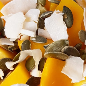 Kwarkontbijt met pompoen, mango, zonnebloempitten in glas