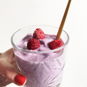 maaltijd smoothie met frambozen vastgehouden door hand