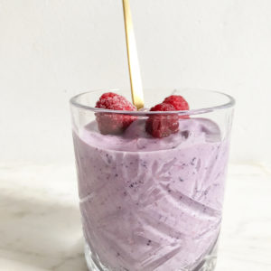 Maaltijd smoothie met frambozen en gouden lepel